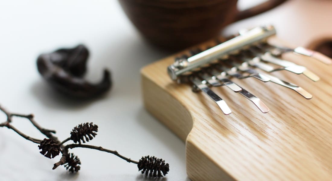 A 9-tine wooden kalimba resting on a table