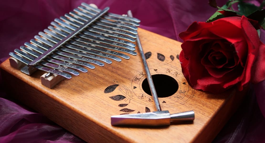 A kalimba with a small tuning hammer placed on top