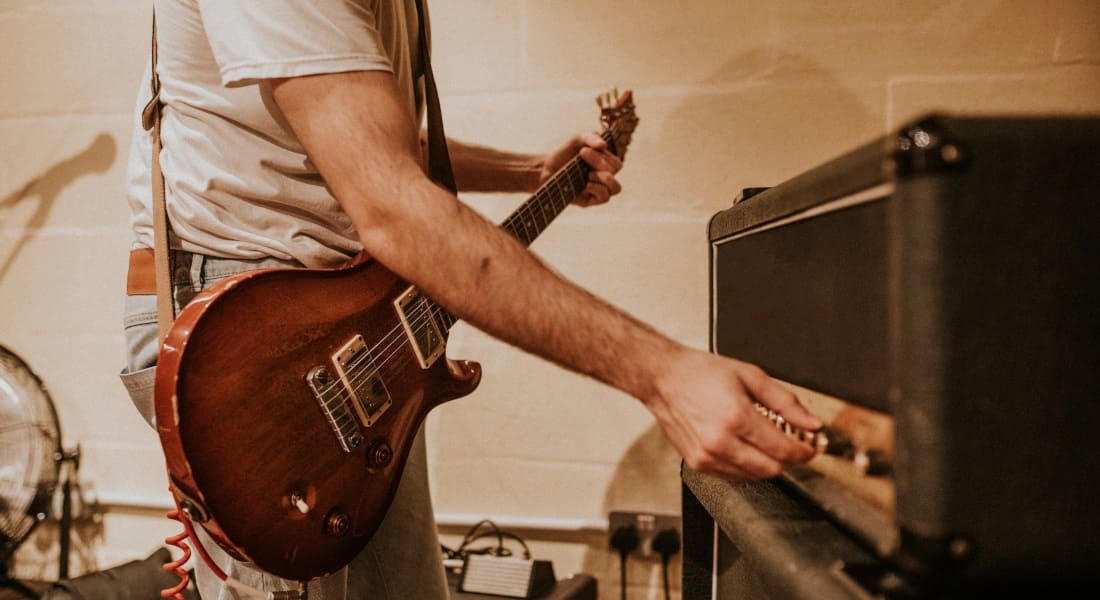 A man plugging in an electric guitar