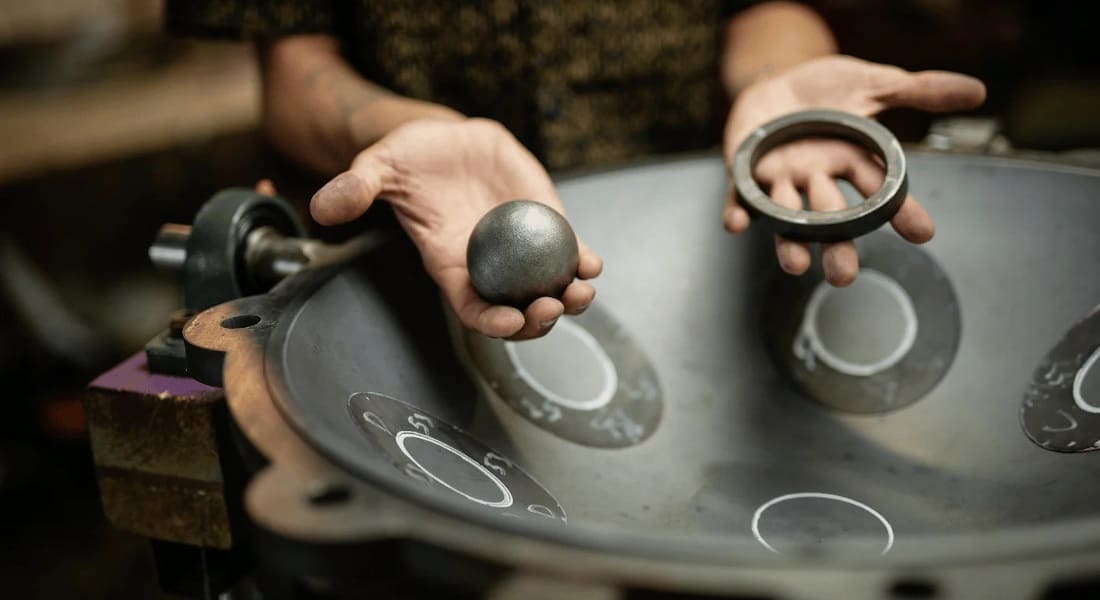 A professional making a handpan with tools