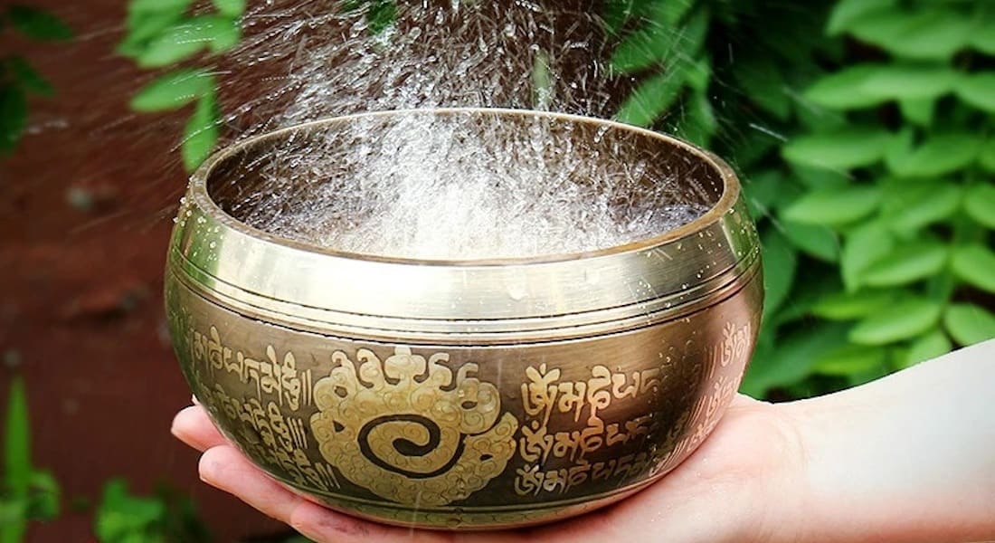 A singing bowl with water inside that vibrates and splashes