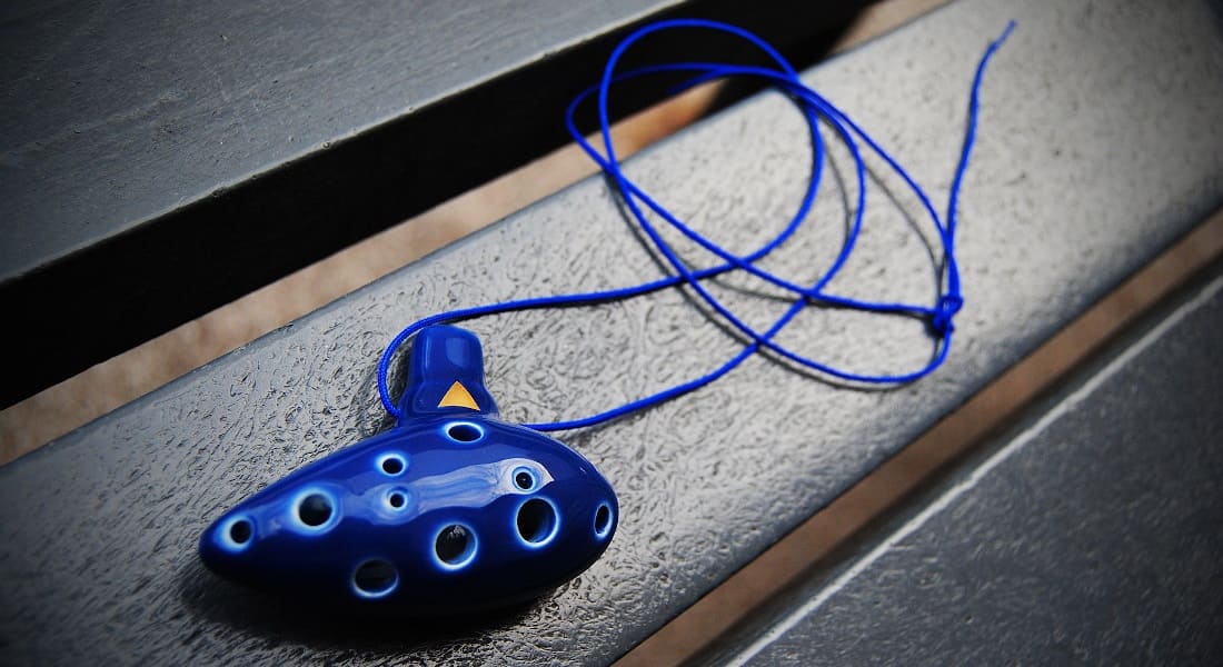 A small blue ocarina with a Zelda video game logo