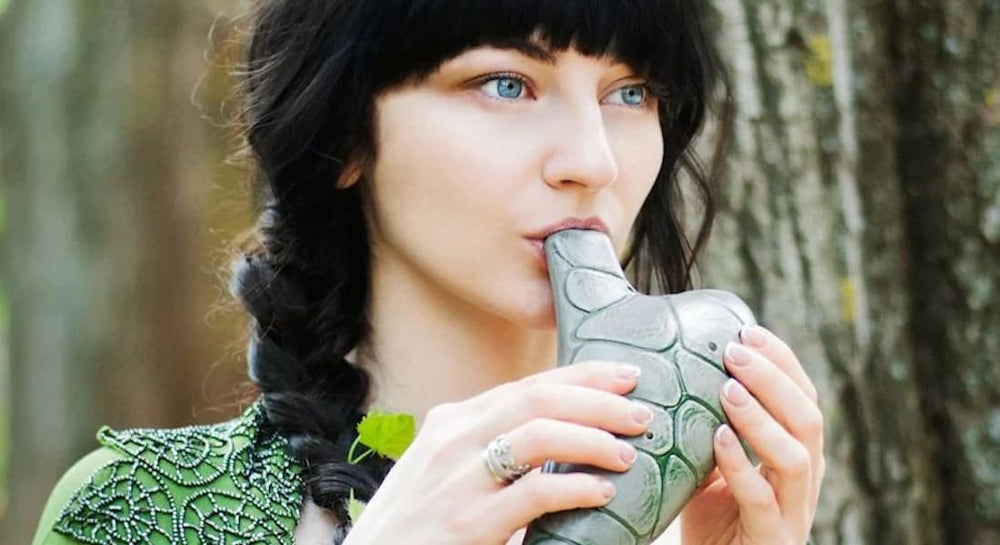 A woman playing a green ocarina, low range
