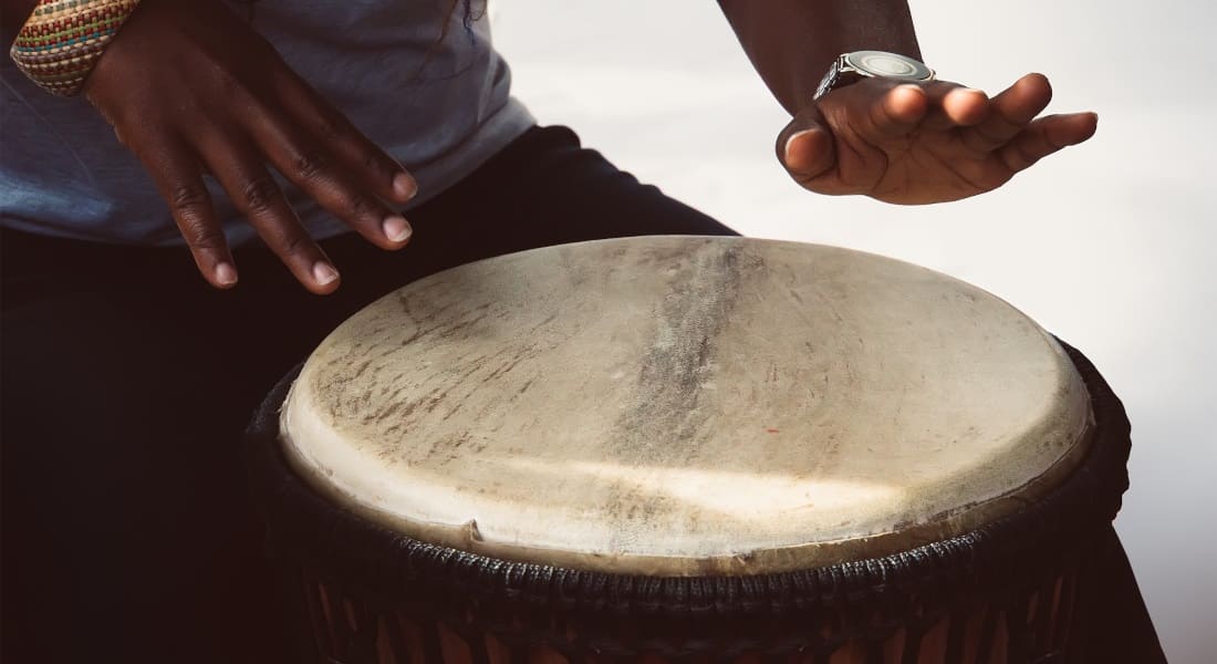 An African man playing a large djembe