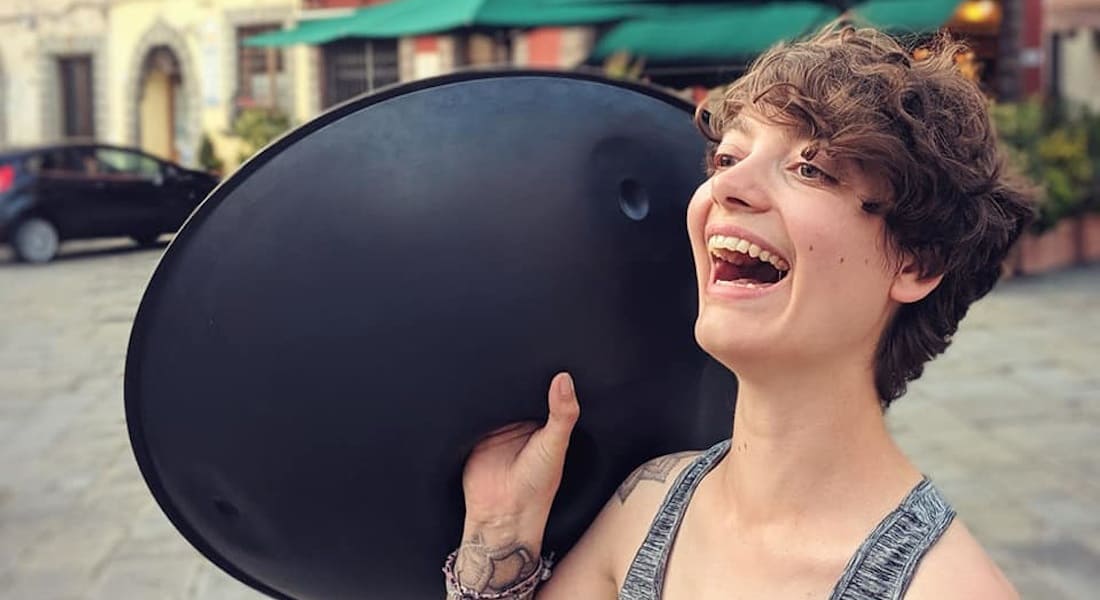 Amy Naylor smiling with a handpan in her hand