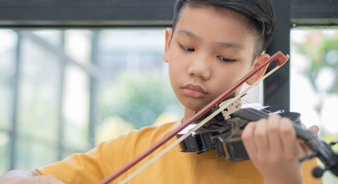 An Asian boy playing the violin