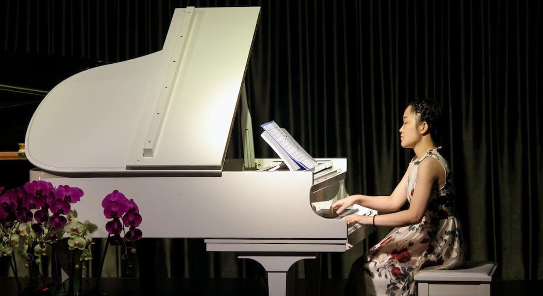An Asian woman playing the piano