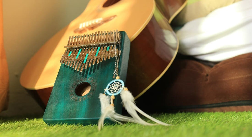 A blue kalimba leaning against a guitar