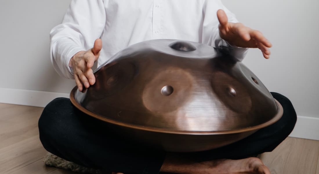 Close-up of a copper-colored Hang drum with a musician