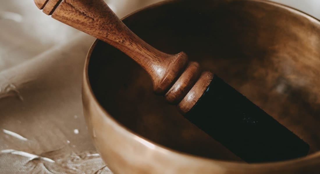 Close-up of a metal Tibetan bowl with a mallet inside