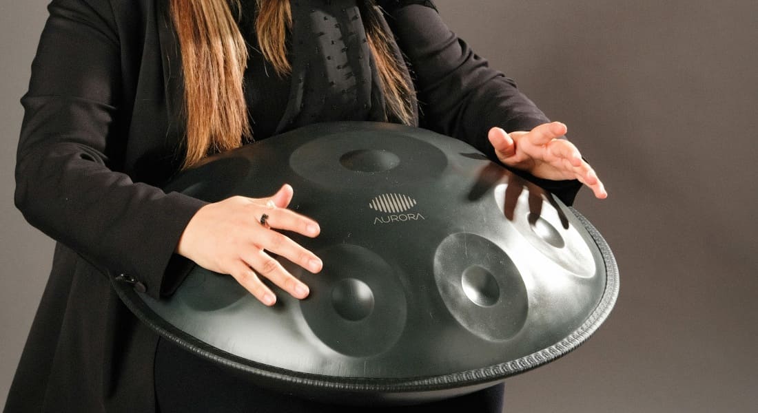 Close-up of a blonde woman playing a handpan