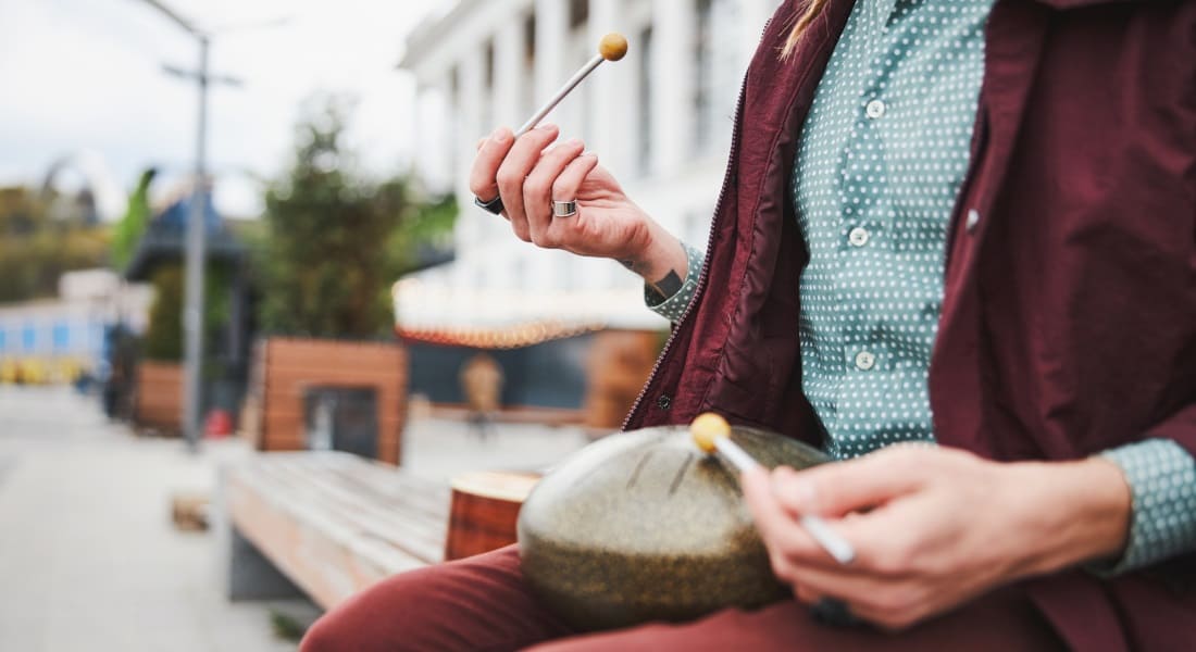 Close-up of a man playing a tongue drum with mallets
