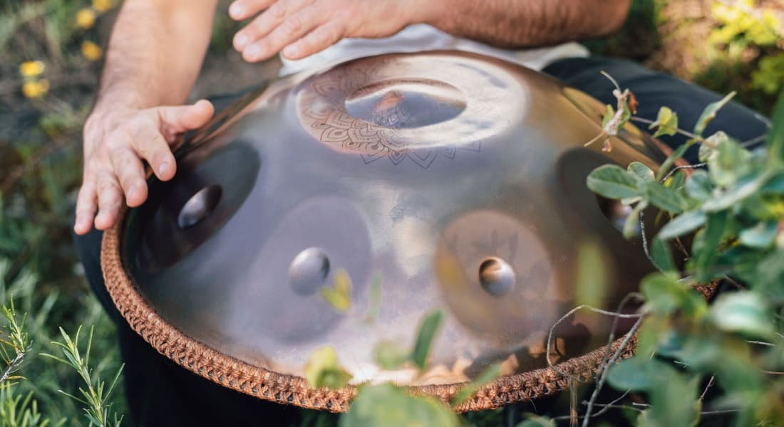 Close-up of a man's hands striking a handpan