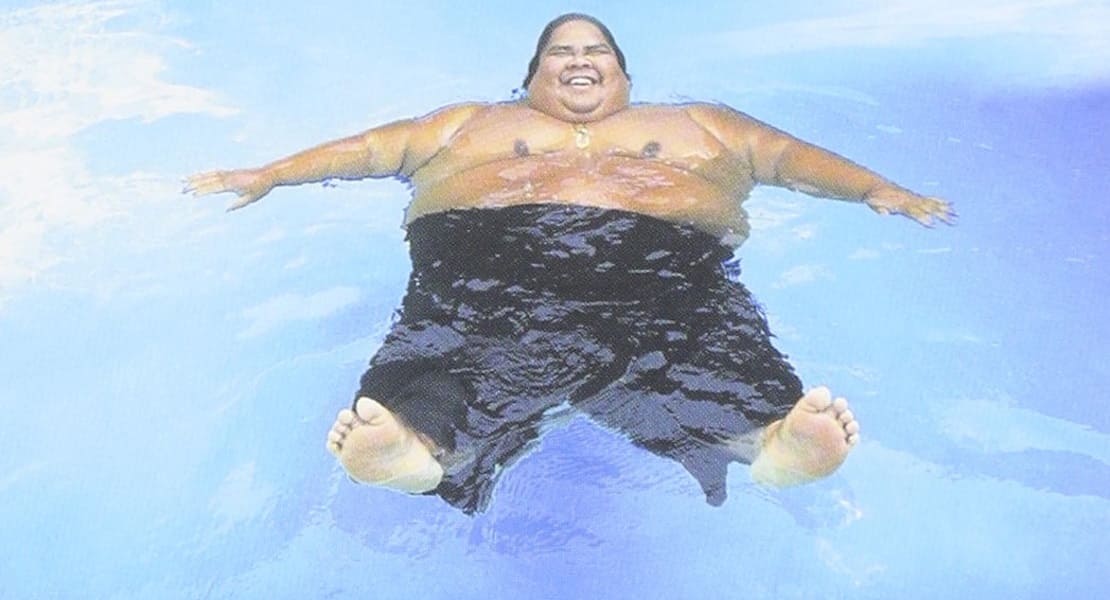 The singer IZ floating in the water and smiling