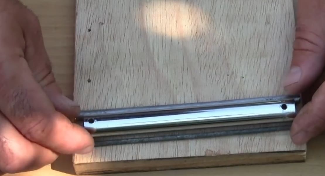A kalimba being made with a metal tube