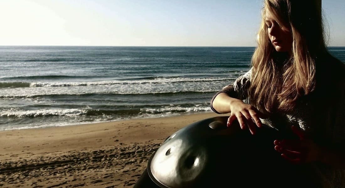 Kate Stone playing handpan on the beach