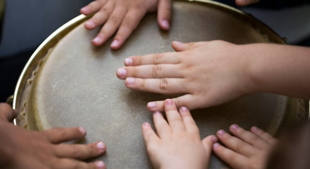 Children's hands on a djembe head