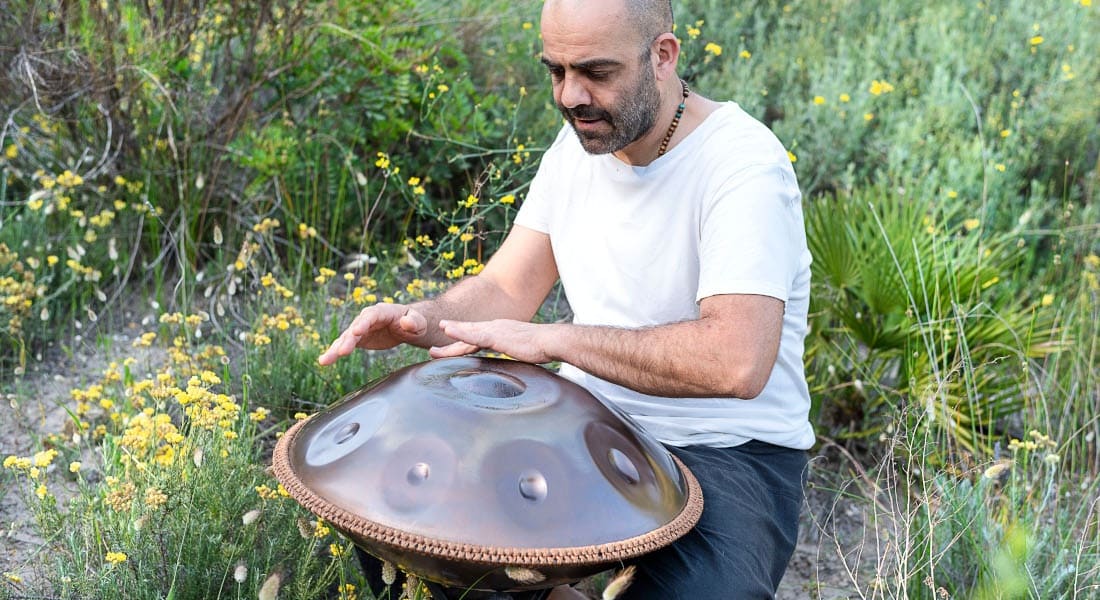 A man enjoying playing the handpan