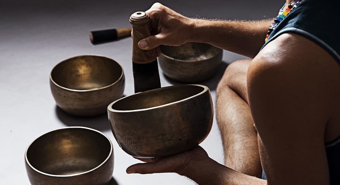 A man seen from behind holding a singing bowl