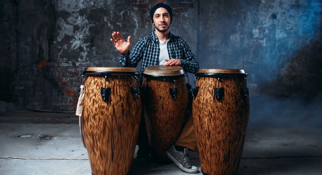 A man playing 3 congas