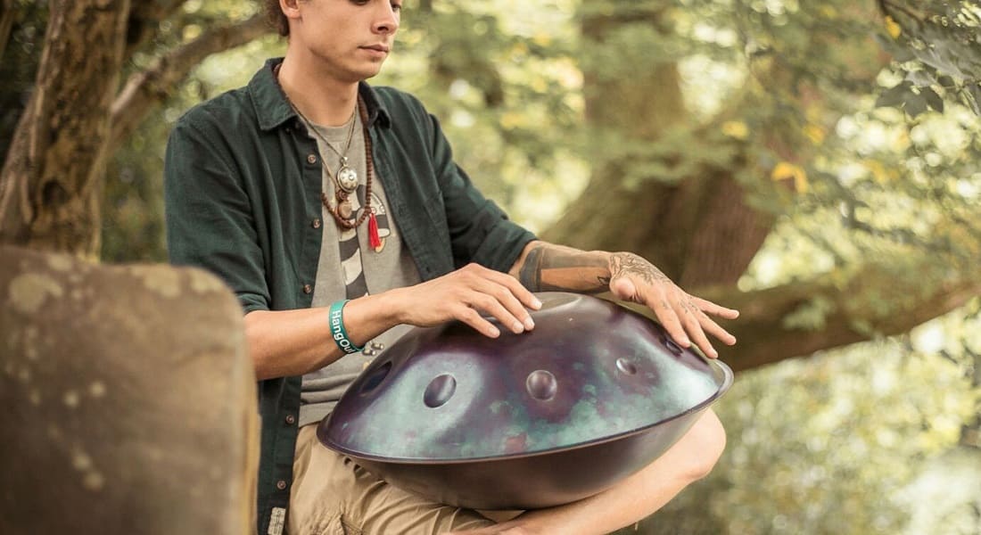A man relaxing with a purple handpan