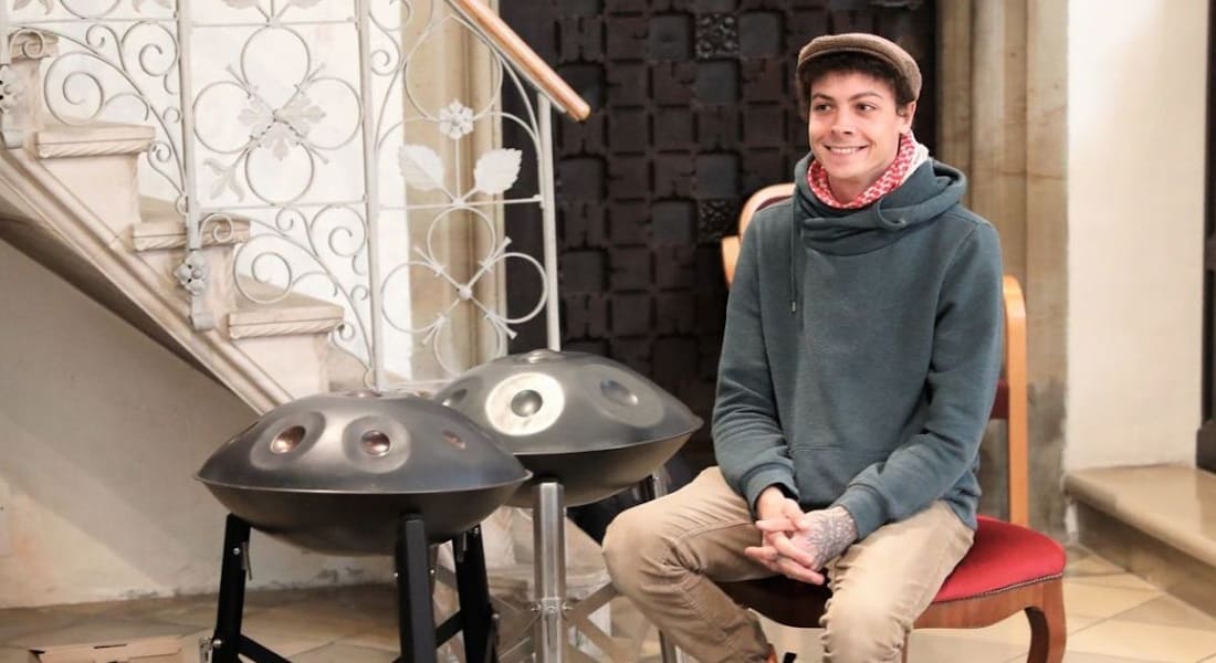 Marcel Hutter sitting on a chair with a handpan next to him