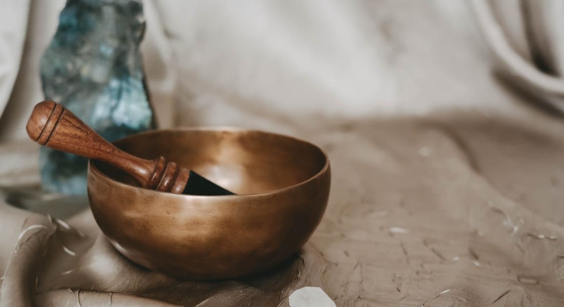 A metal Tibetan bowl resting on a tablecloth