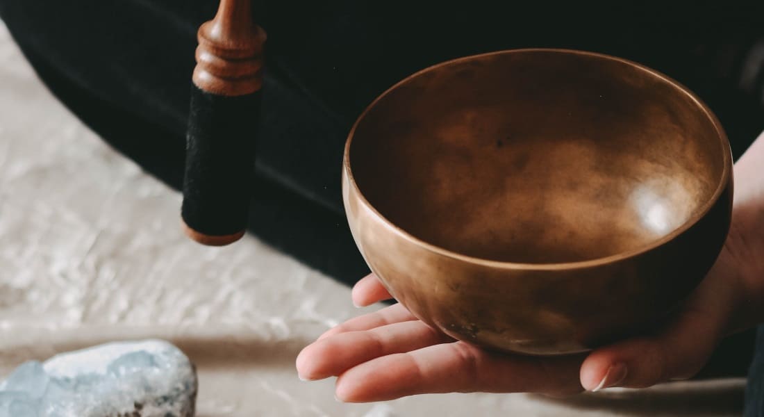 A metal Tibetan singing bowl with a mallet