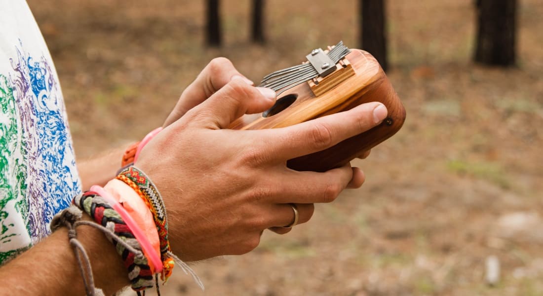 Older hands playing the mbira