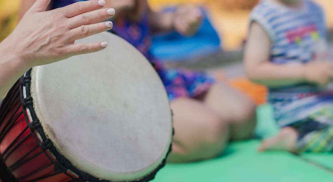 One hand placed in front of a djembe