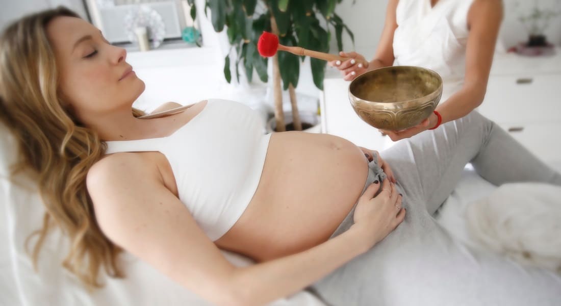 A pregnant woman lying down during a sound massage