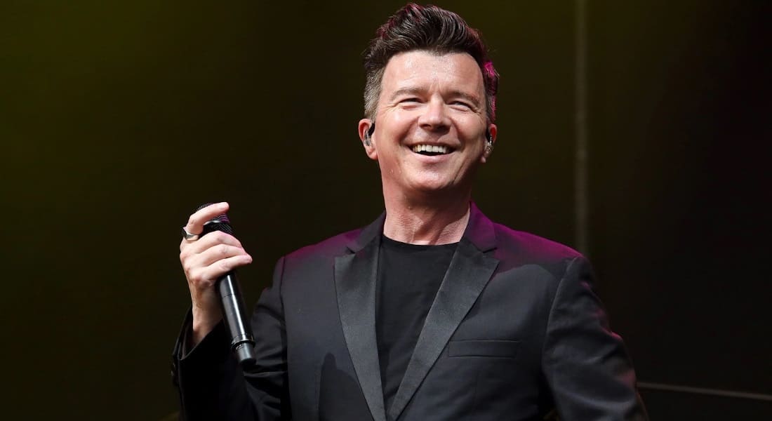 Rick Astley in concert holding a microphone