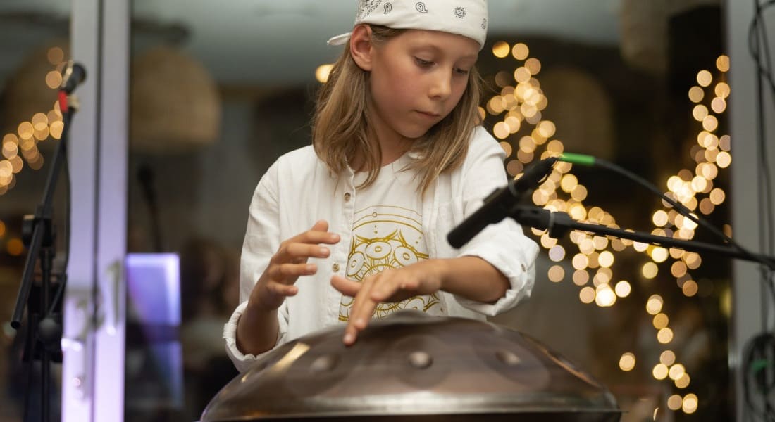 Sunni Holden playing the handpan with a microphone