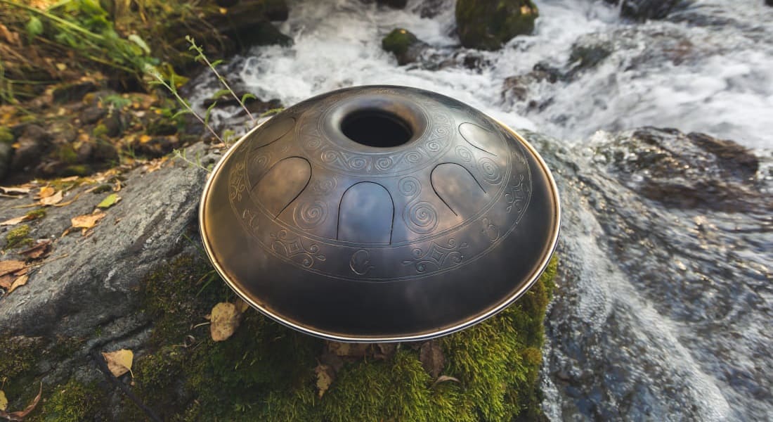 A tank drum on the ground next to a stream