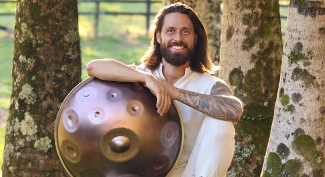 Taylor Sol sitting holding a handpan and smiling