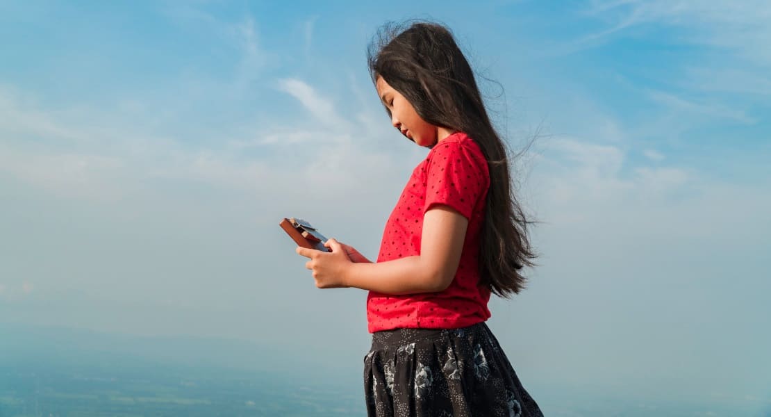 A teenage girl in a red dress playing the kalimba