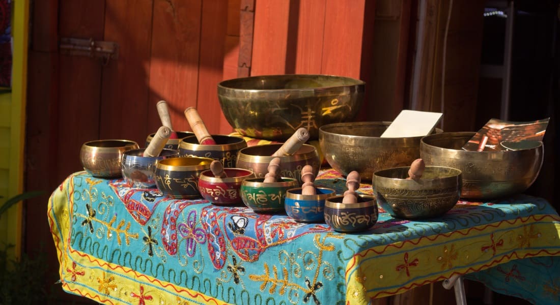 About ten singing bowls arranged on a table