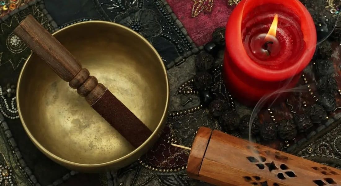 A Tibetan bowl next to a candle