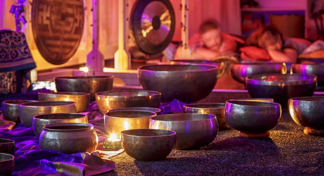 About fifteen Tibetan singing bowls on a carpet