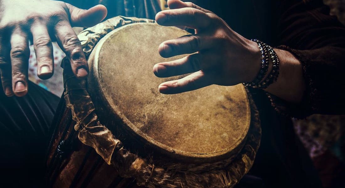 Two hands playing an African drum