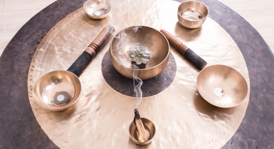 Two mallets placed among 6 Tibetan singing bowls