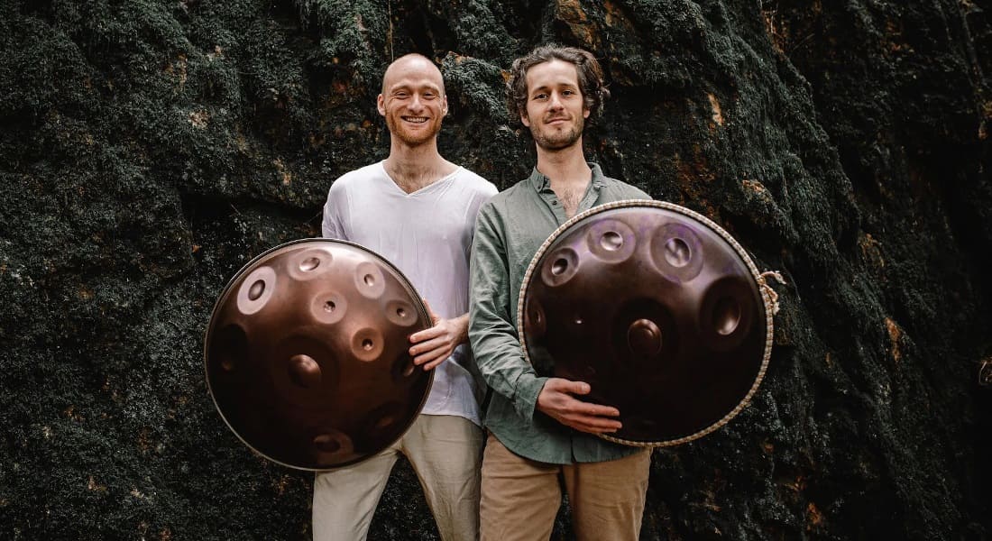 The two members of Yatao smiling with a handpan in their hands
