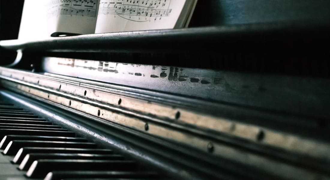 An old used piano with sheet music