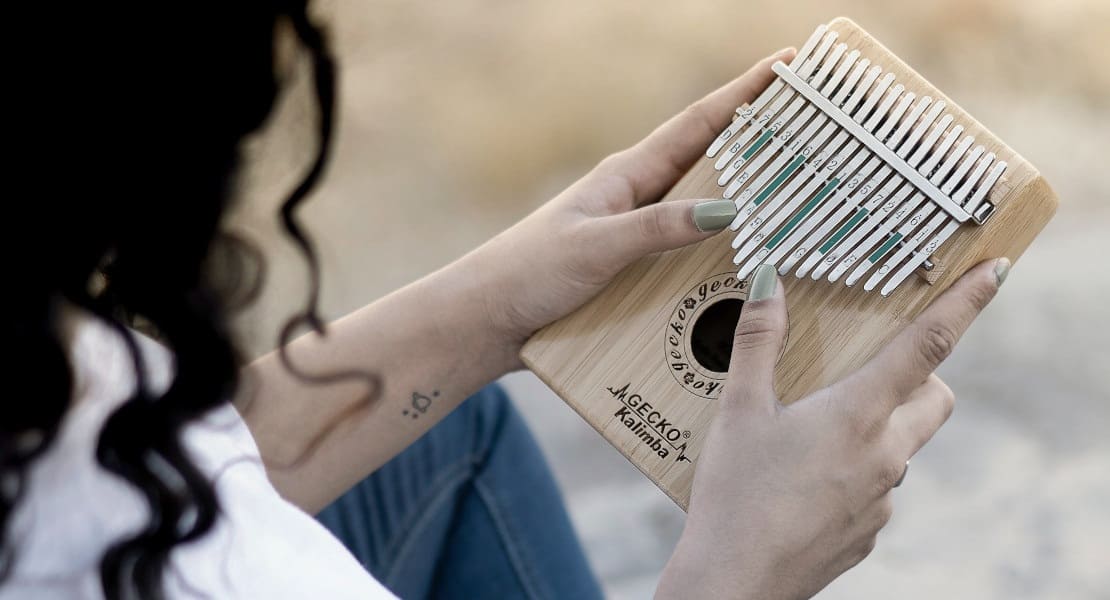 Woman seen from behind playing a Gecko brand kalimba