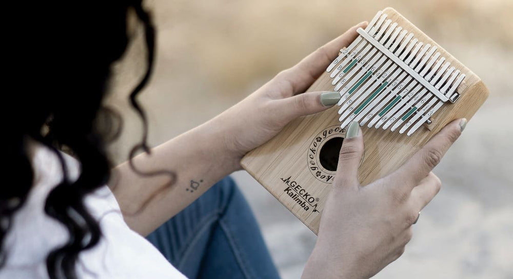 A woman with green nails playing the sanza