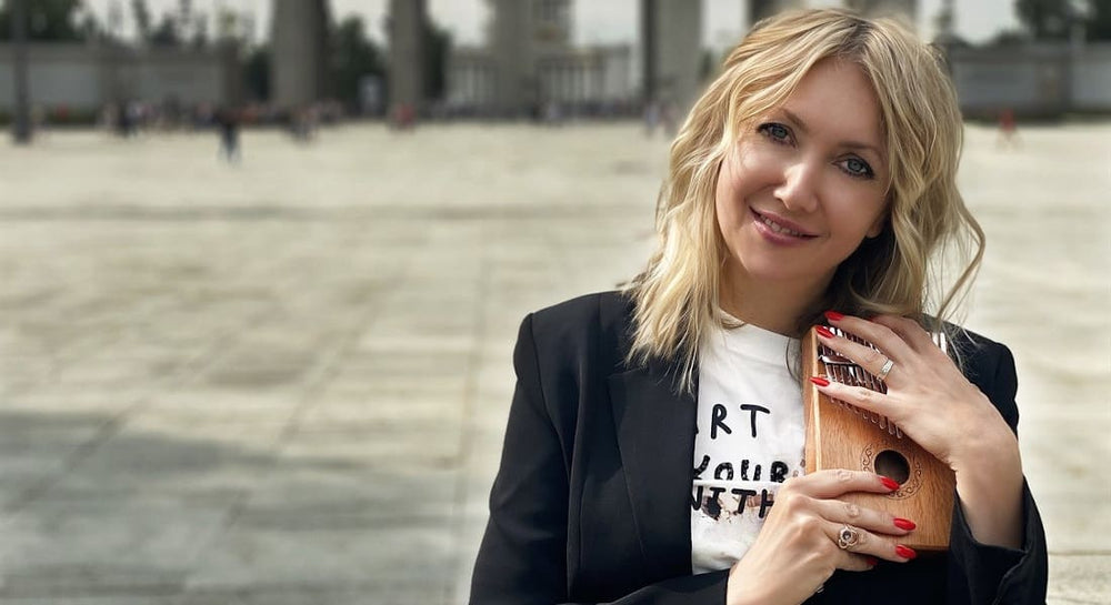 A woman holding a kalimba tightly against her
