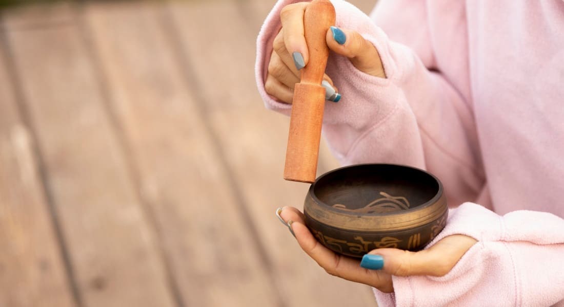 A woman in a robe with a singing bowl