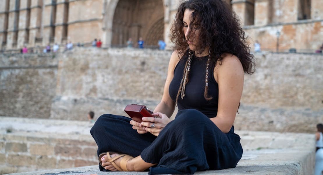 A woman sitting cross-legged relaxing with a kalimba
