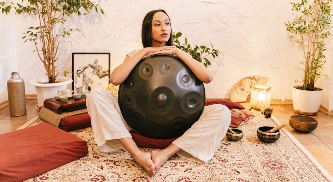 A woman in a yoga studio with a handpan