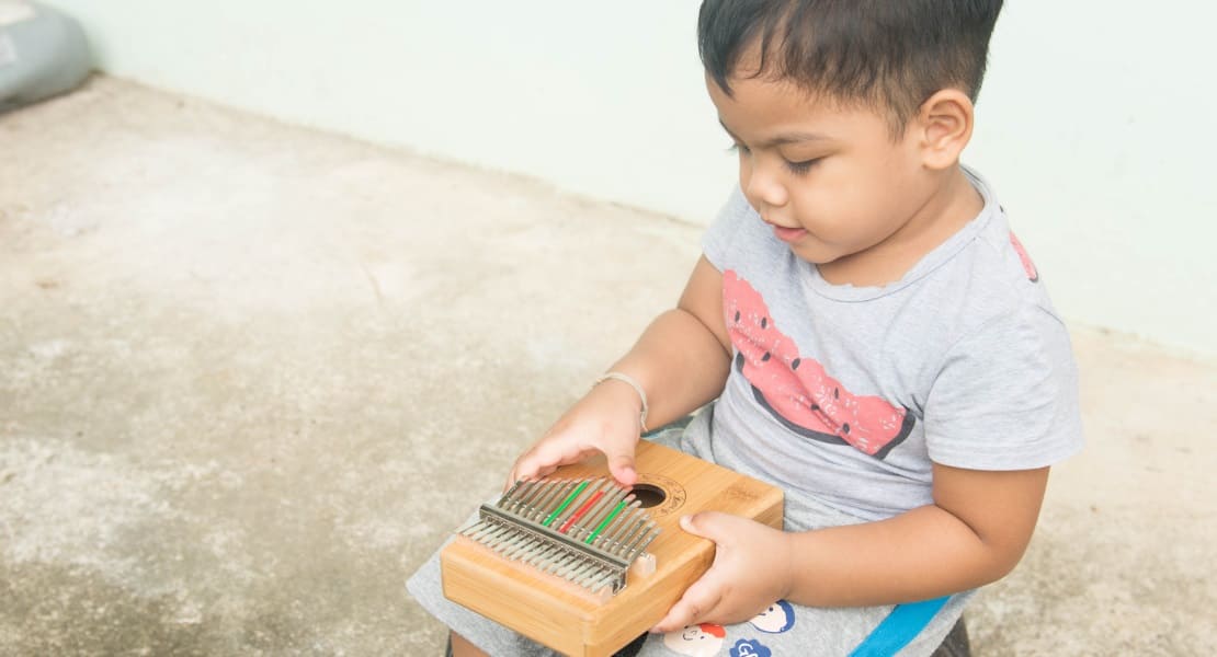 A young child playing the kalimba